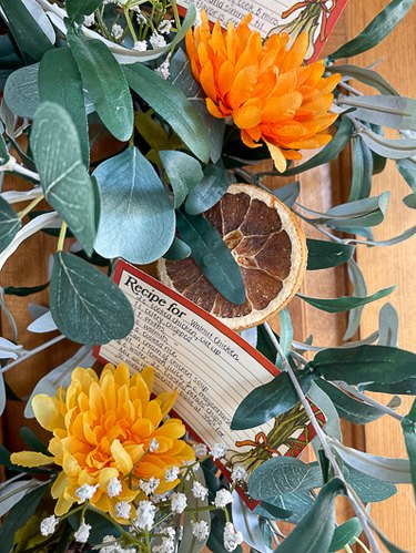 dried orange tucked into recipe card wreath