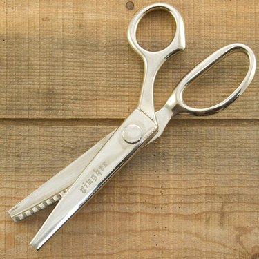 Gingher pinking shears against a wooden background