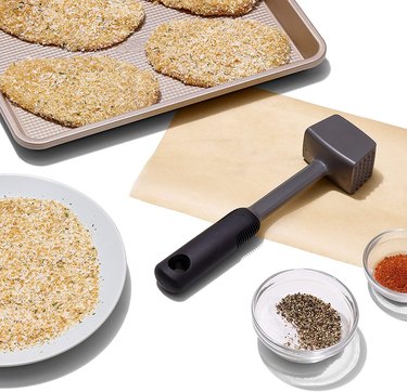 OXO Good Grips Meat Tenderizer Placed Next to Sheet Pan of Schnitzel and Small Spice Bowls