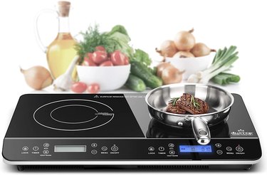 Duxtop dual induction cooktop, pictured with steaks in a pan and ingredients in the background