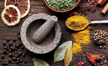 mortar and pestle surrounded by spices