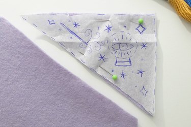 Magical embroidery pattern pinned to purple felt