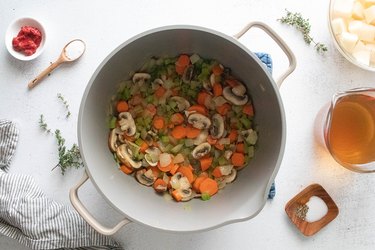 Mushrooms, onion, celery, and carrots in a pot