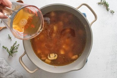 Pouring vegetable broth into a pot