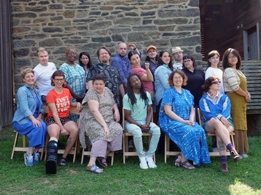 Tim (second row, standing with glasses and a black and white T-shirt) and Tiernan (seated, directly in front of Tim) pose with their employees