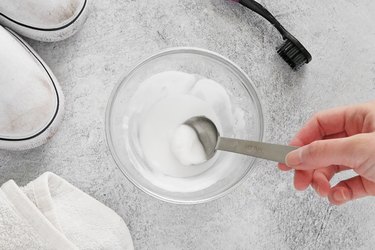 Mixing baking soda and vinegar to form a paste