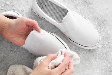 Scrubbing paste off shoes with a towel