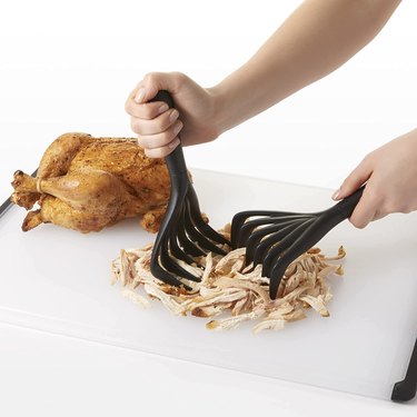 OXO Good Grips Meat Shredding Claws Being Used to Shred Chicken on a Cutting Board
