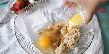 Large glass mixing bowl with brown sugar, egg and melted butter