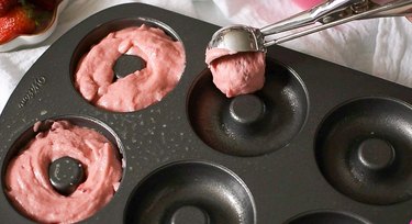 Pouring pink mochi donut batter into a donut mold