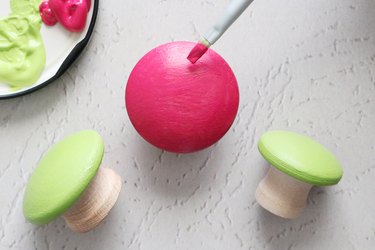 Coat the top of wooden cabinet knobs with acrylic paint