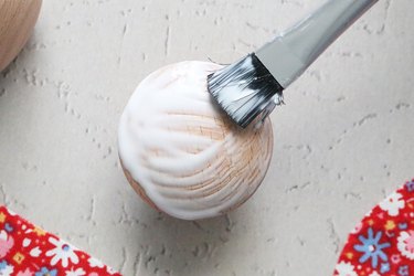 Coat the cabinet knob with decoupage glue