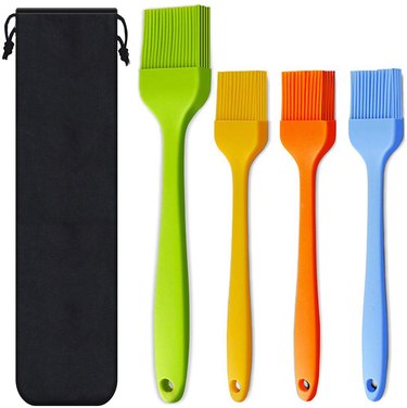 Set of four colorful silicone basting brushes on a white ground
