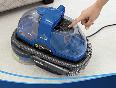 A blue upholstery cleaner on a white carpet.
