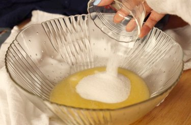 Adding sugar to a bowl.