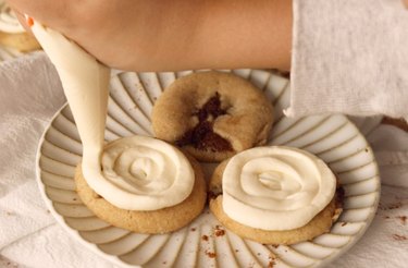 Piping cookies with cream cheese frosting.