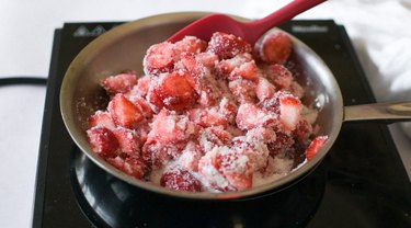 Pan filled with chopped strawberries mixed with granulated sugar