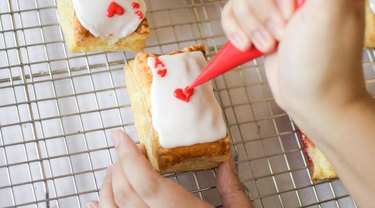 Piping a heart on a playing card–themed tart