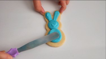 Smoothing frosting on bunny cookie