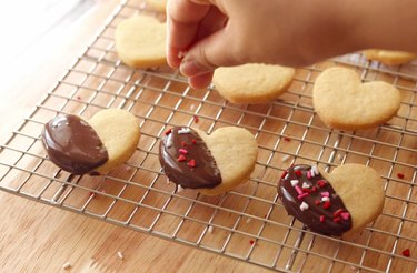 Topping chocolate-dipped shortbread cookies with cute heart sprinkles.