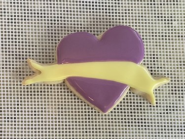 Heart-shaped sugar cookie with yellow banner and purple heart