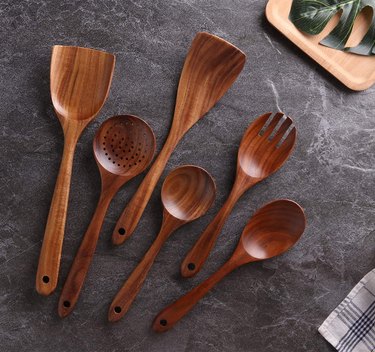 Wooden cooking utensils on a gray marble countertop.