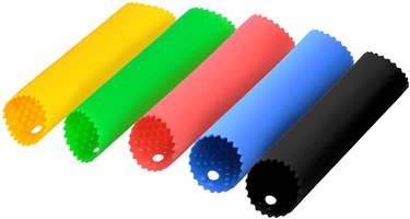 Set of five colorful garlic peelers on a white ground