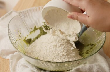 Pouring dry ingredients into mixing bowl