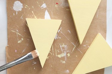 Painting wood triangles with light yellow paint