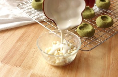 Pouring heavy cream into bowl with white chocolate chips