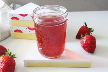 Red drink in a Mason jar on a strawberry shortcake coaster