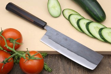 Yoshihiro blue-steel nakiri displayed on a wooden cutting board with vegetables
