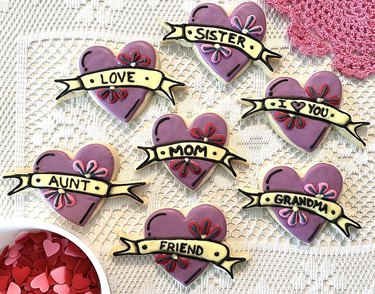 Purple heart-shaped Mother's Day cookies against white lace background
