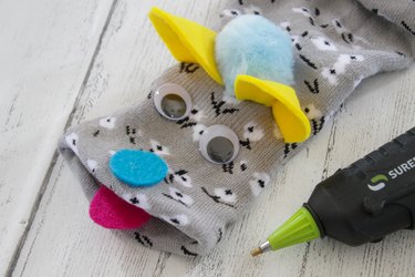 attach ears, eyes, nose, tongue and pom-pom with hot glue