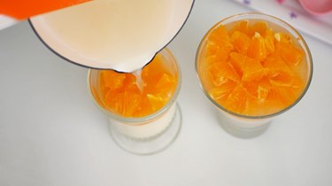Pouring gelatin mix over panna cotta and oranges