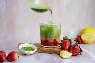 pouring matcha over the sparkling water and strawberry-lemon mixture.