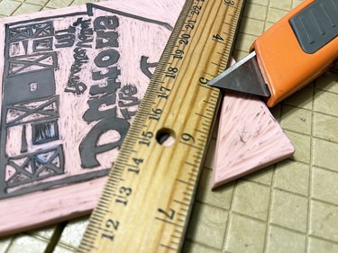 Rubber block with carved design getting trimmed by craft knife