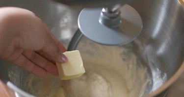 Adding butter to pan de coco dough
