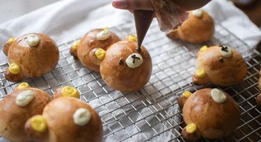 Drawing Rilakkuma faces on pan de coco with melted chocolate