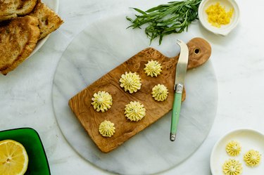 butter rosettes on cutting board with butter knife.