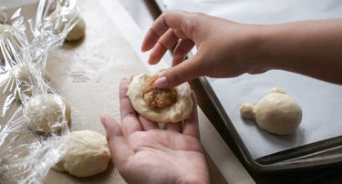 Adding coconut filling to flattened dough