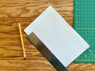 White sheet of paper and pencil next to green grid board