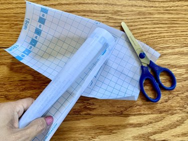 Grid lines on two pieces of contact paper and a pair of scissors