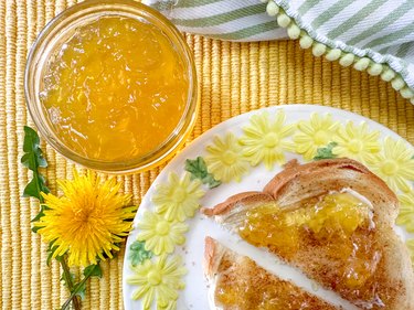 jar of dandelion jelly and toast on a yellow flower plate