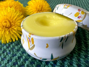 finished dandelion salve in a tin container