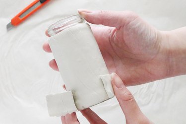Wrapping clay around bottom of bottle