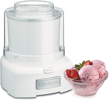Compact Cuisinart ice cream maker displayed on a white ground with strawberry ice cream