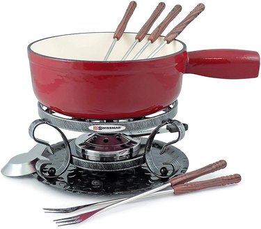 Swissmar cast iron fondue pot in red, shown on a white ground