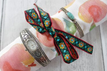 bracelets on outside of jewelry roll with ribbon