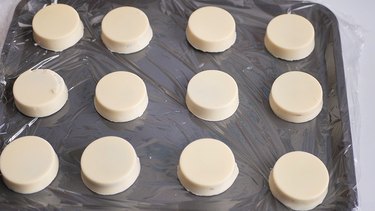 White chocolate–covered Oreos on plastic-lined tray